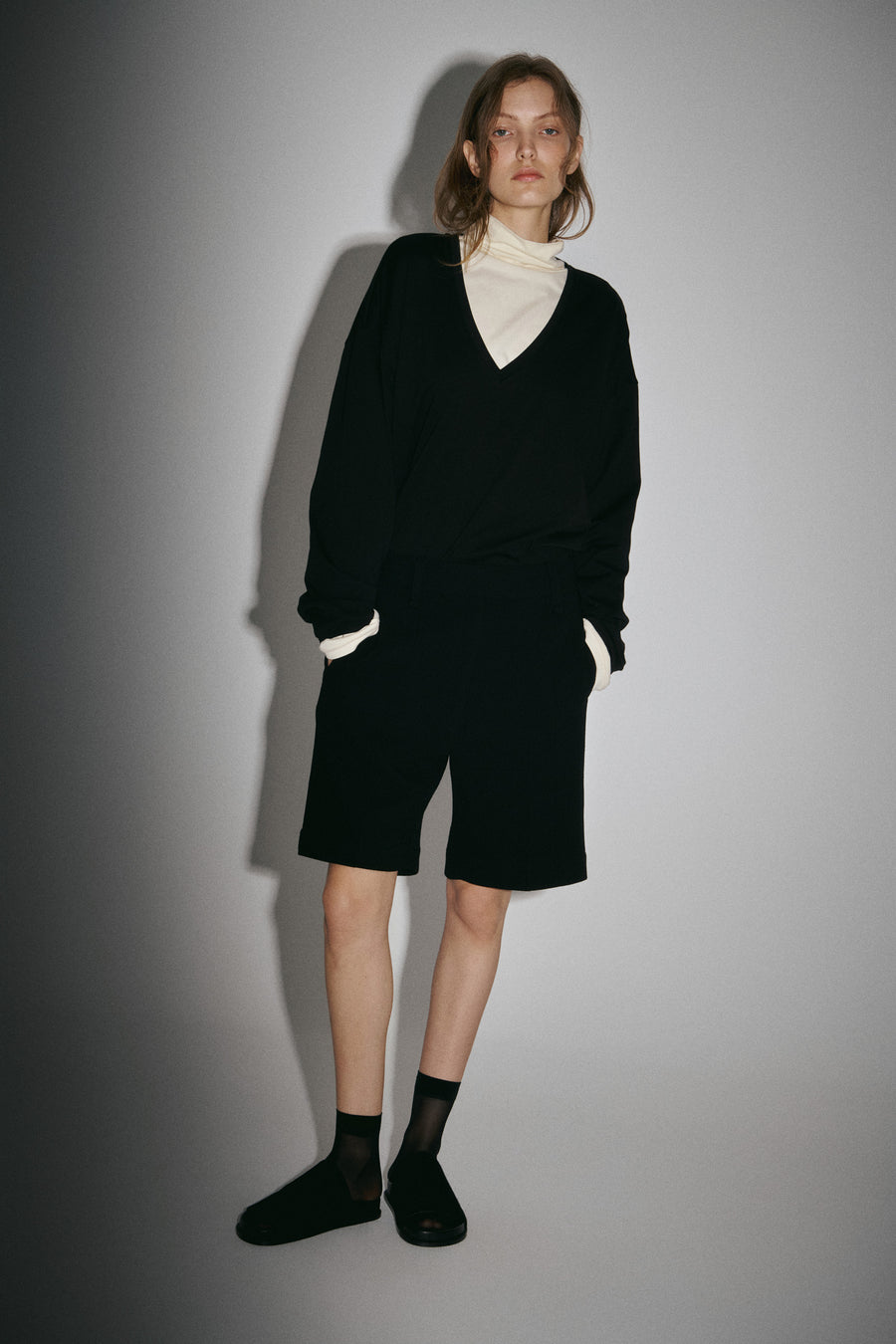 Olisha wears the Persey Top in Black layered over the Miles Top in Lemon with the Keely Short and Luca Sandal.  