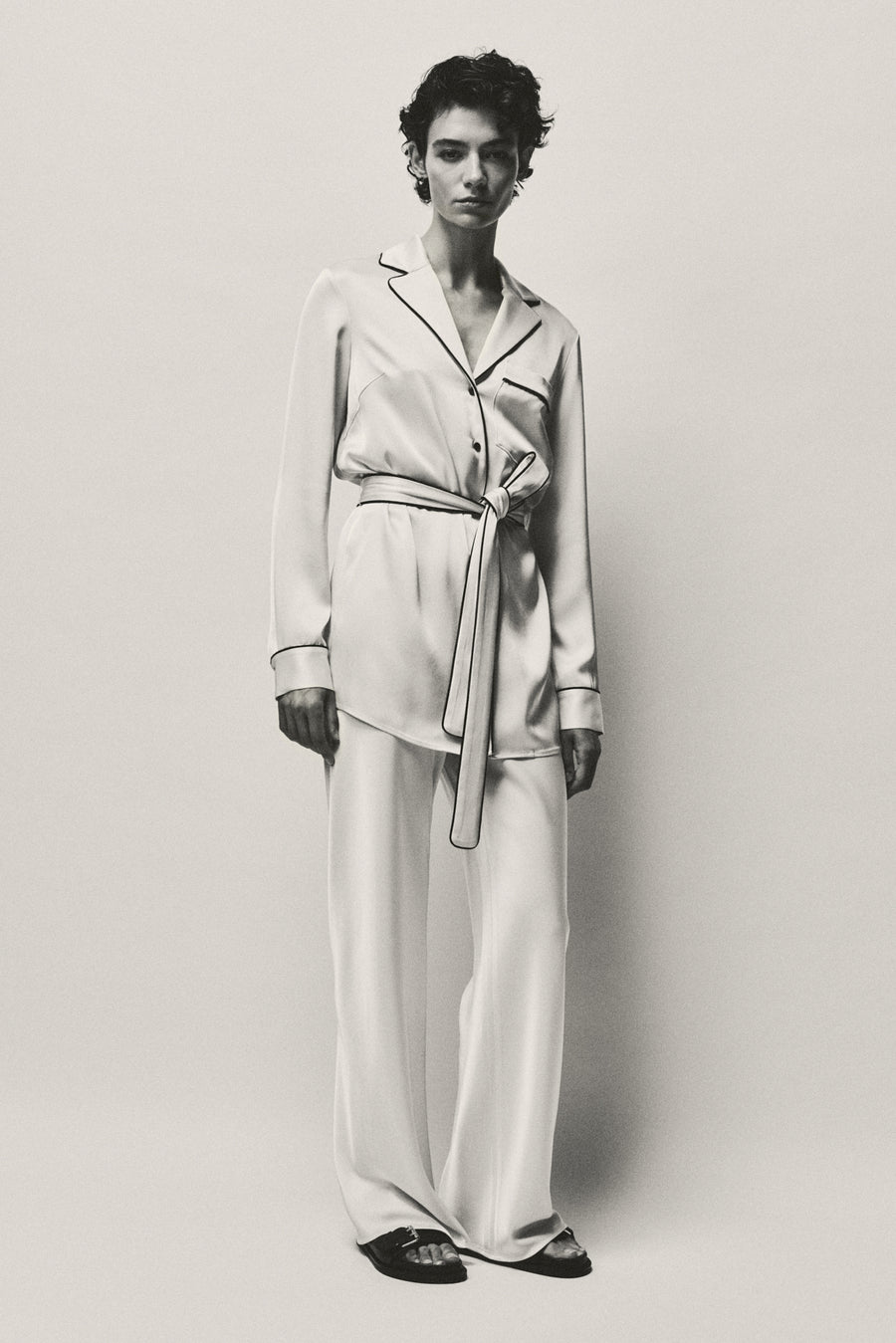 Anna Lee wears the Ivy Shirt and Myrna Pant in Oyster with the Leon Sandal. 